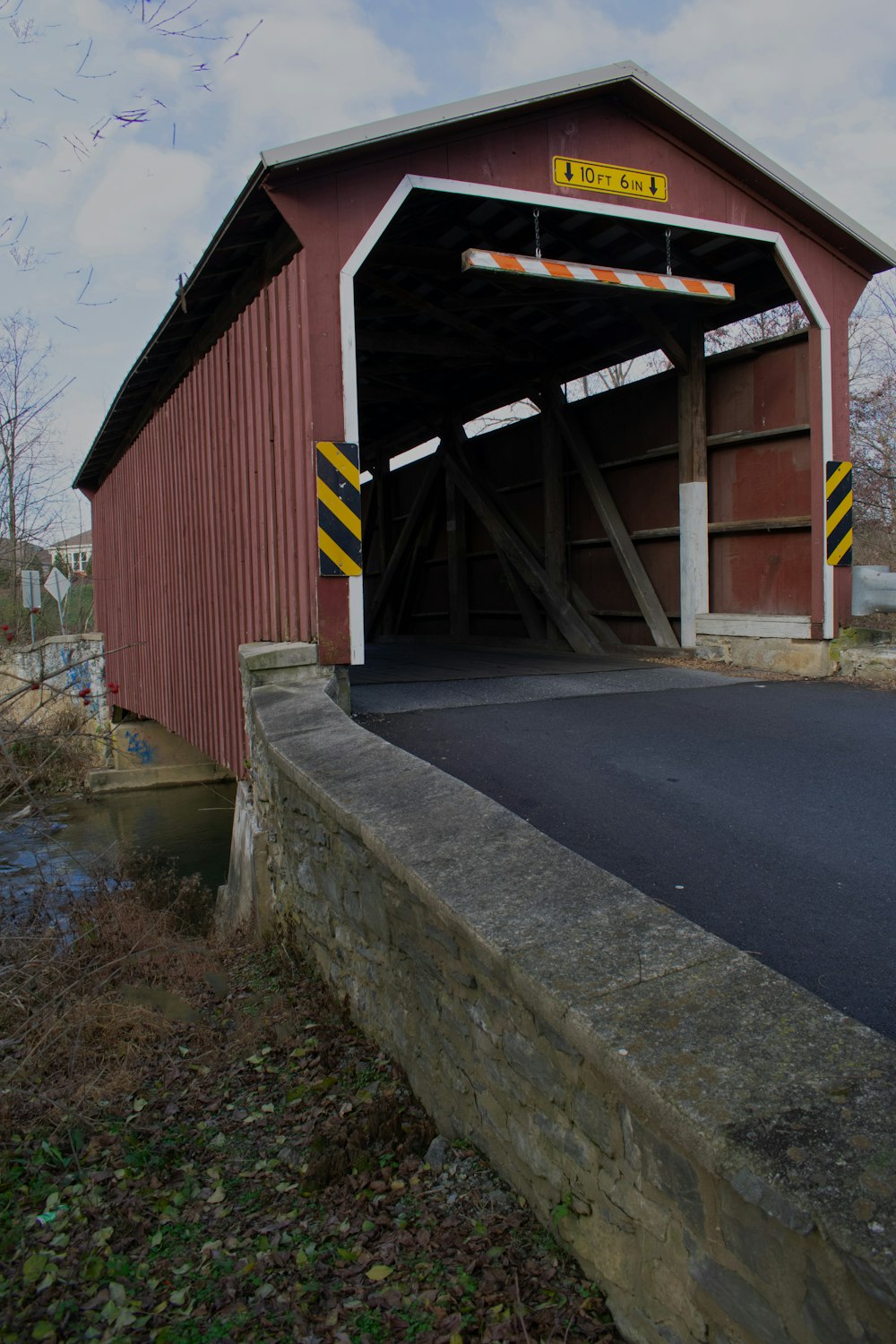 a large red covered bridge over a river