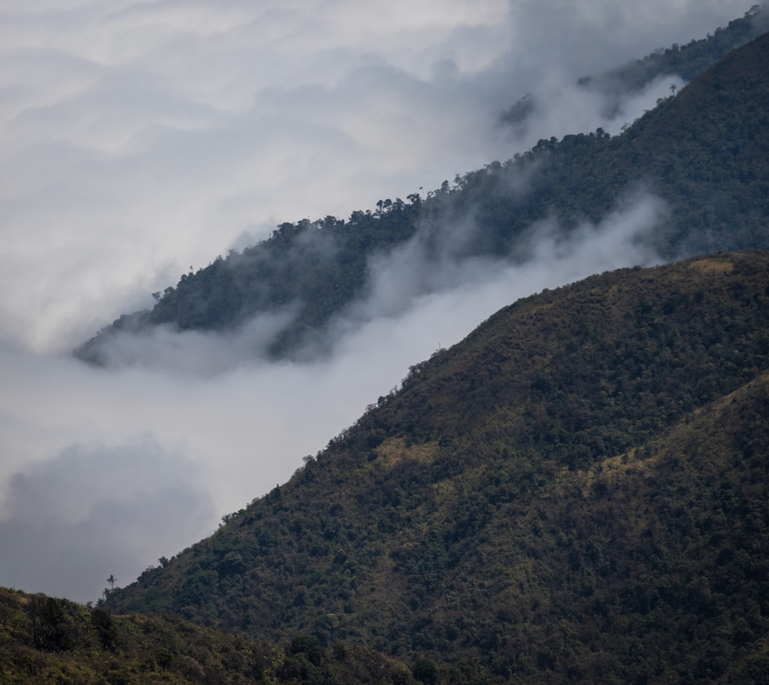 a mountain covered in fog and low lying clouds,