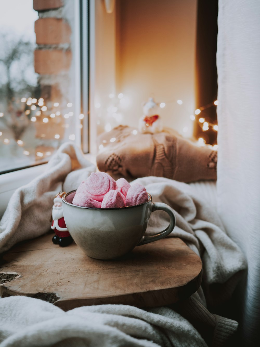 a cup of ice cream sitting on a table next to a window