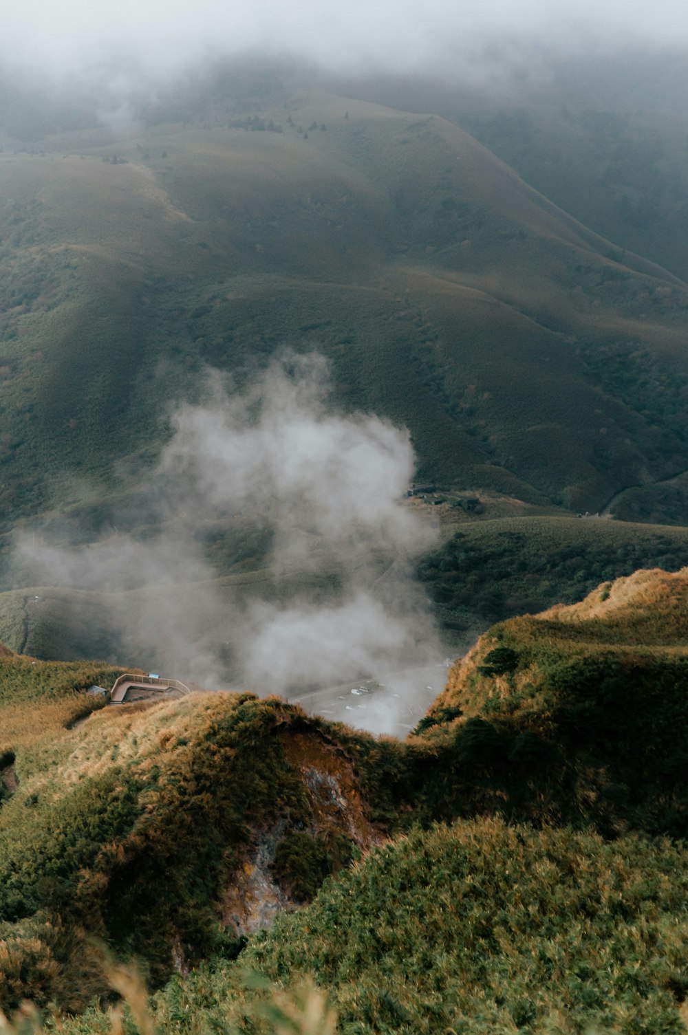 steam rises from the ground in a valley