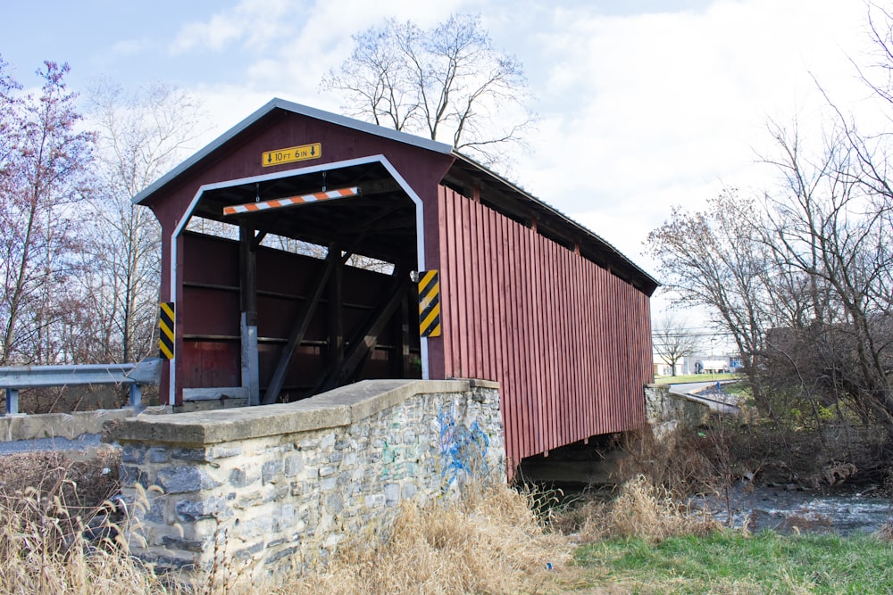 a red covered bridge over a small stream