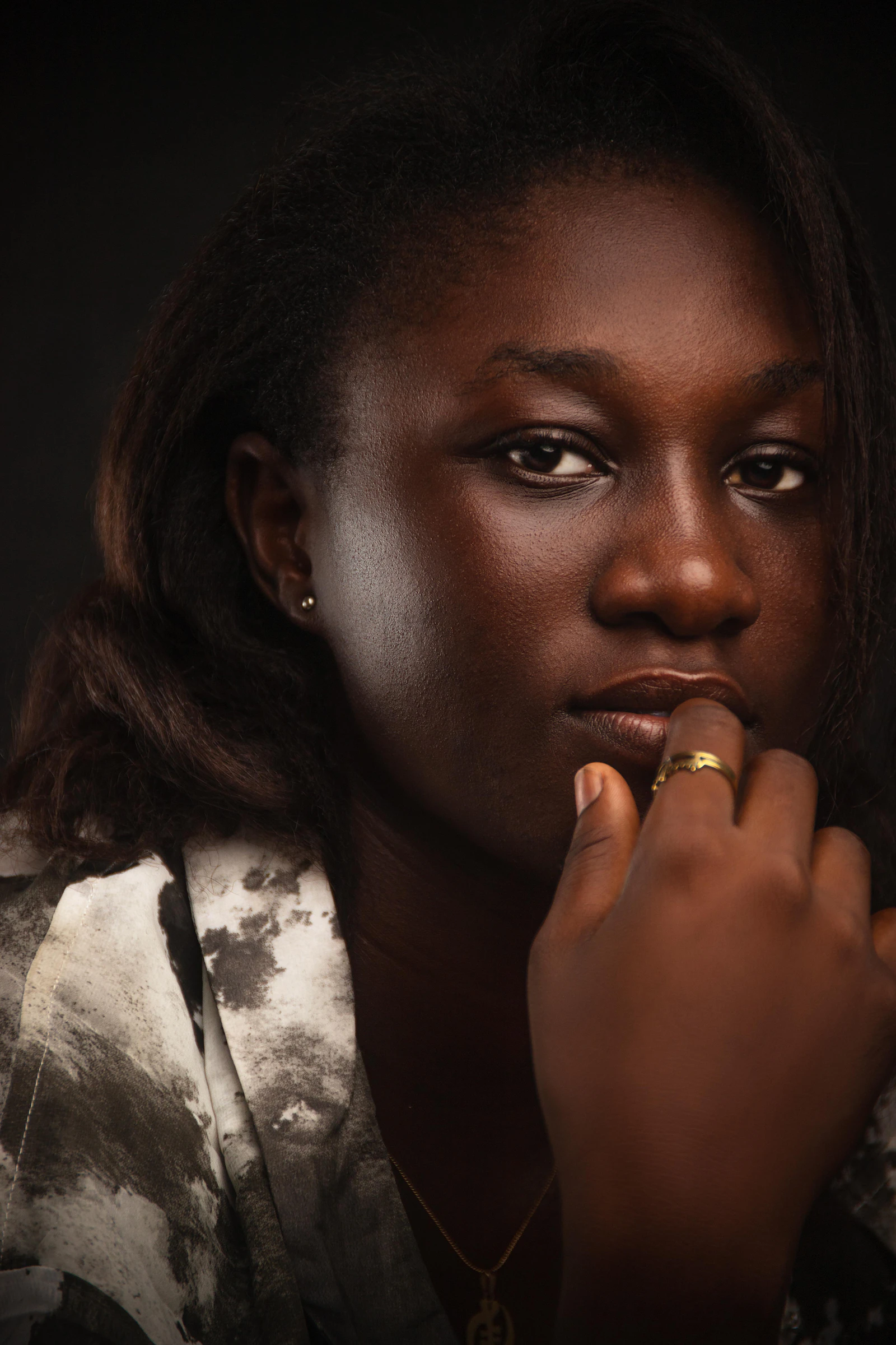 Portrait of a Black woman with focus on her hand and a ring