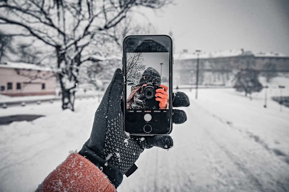 Osoba fotografująca zaśnieżoną ulicę