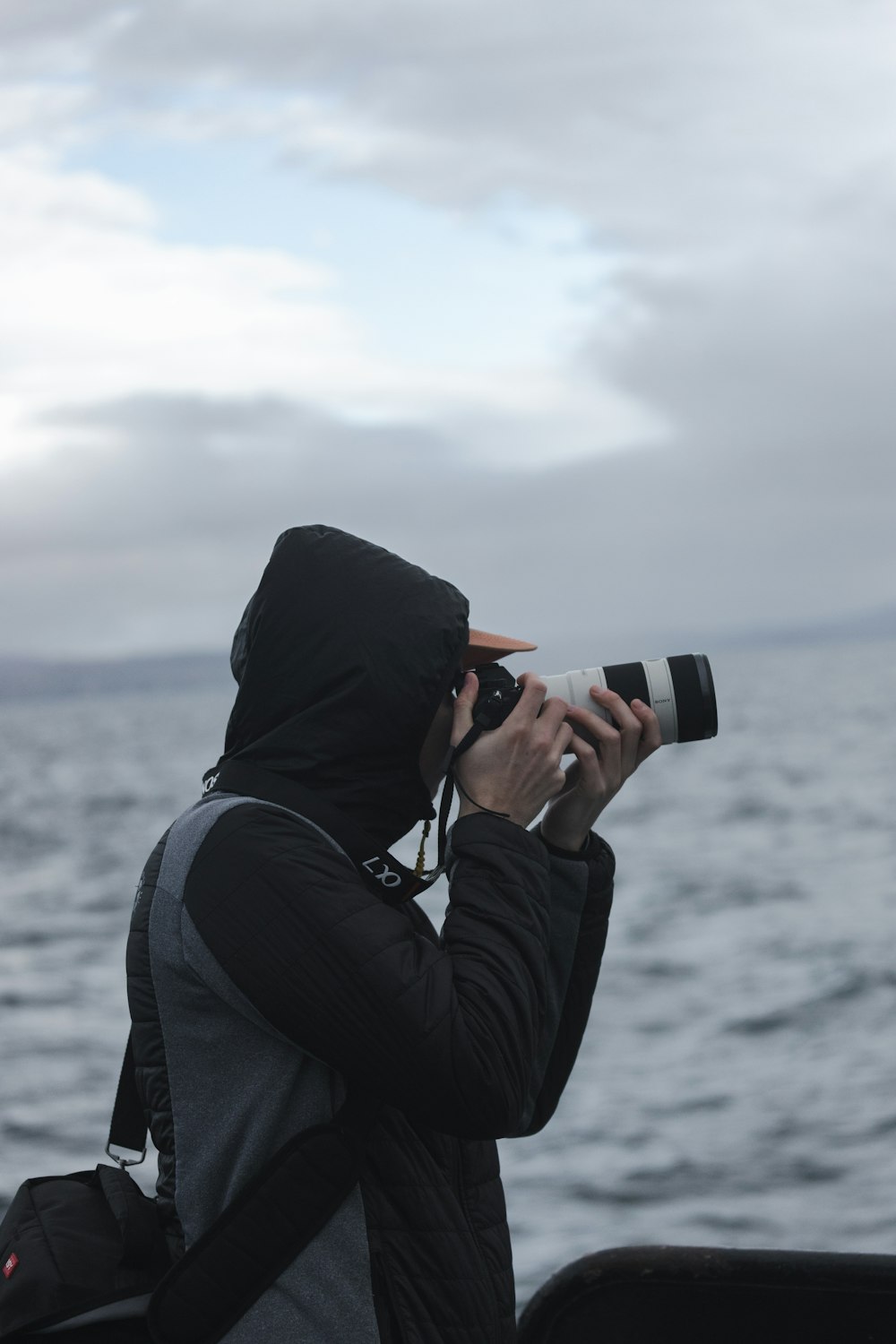 a person taking a picture of the ocean with a camera