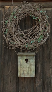 A handcrafted wooden mailbox with intricate carvings and a rich natural finish, standing beside a charming garden path.