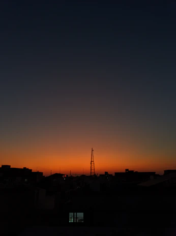 A city skyline at dusk with communication towers subtly highlighted, symbolizing Evonet’s reach.