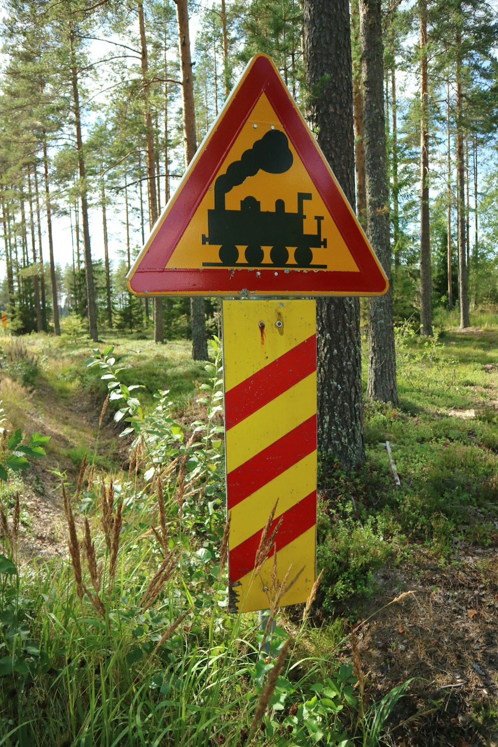 a sign warning of a train crossing in the woods