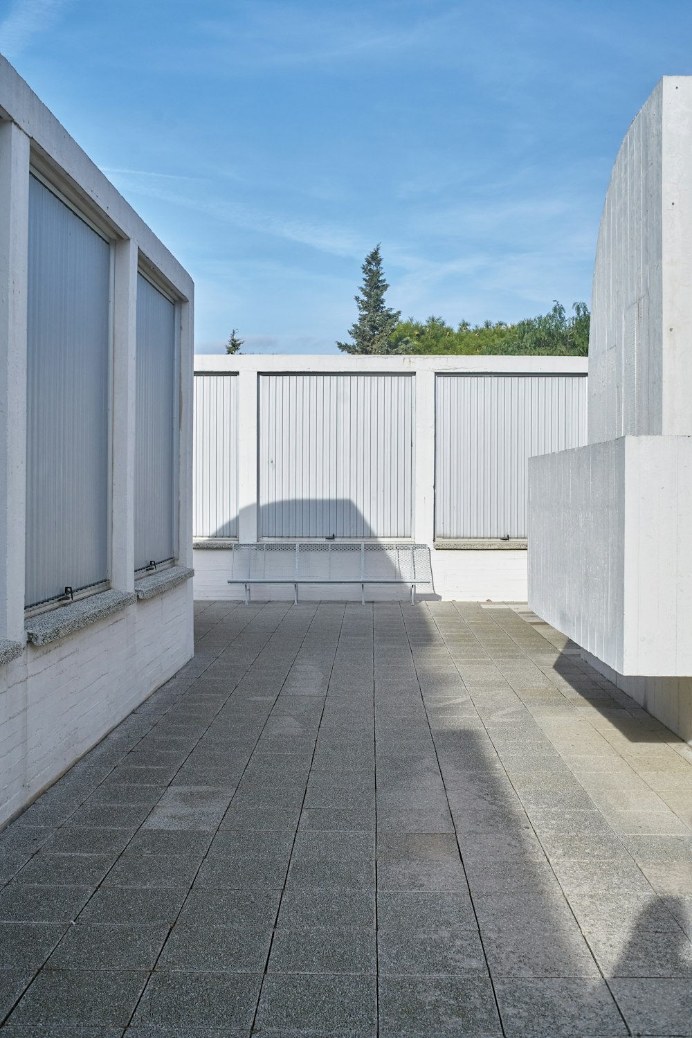 a white building with a bench in the middle of it