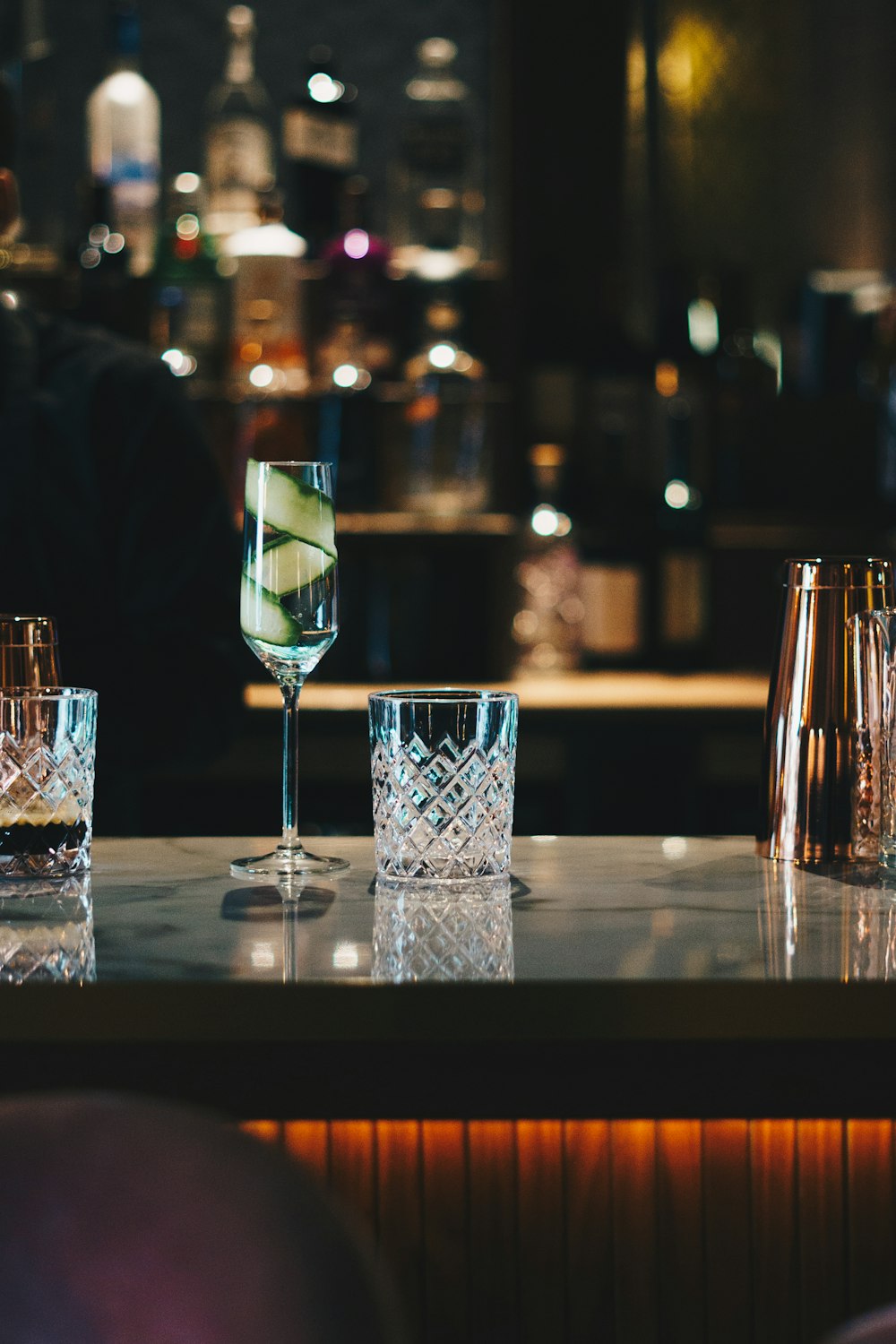 three glasses of alcohol on a bar with a view of a city