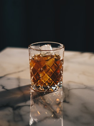 a glass of whiskey on a marble table