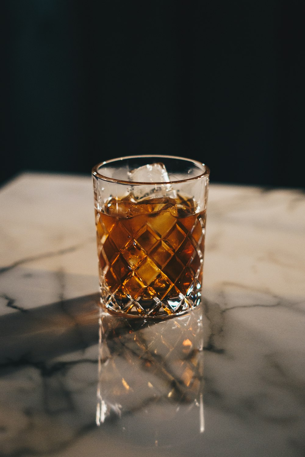 un vaso de whisky sobre una mesa de mármol