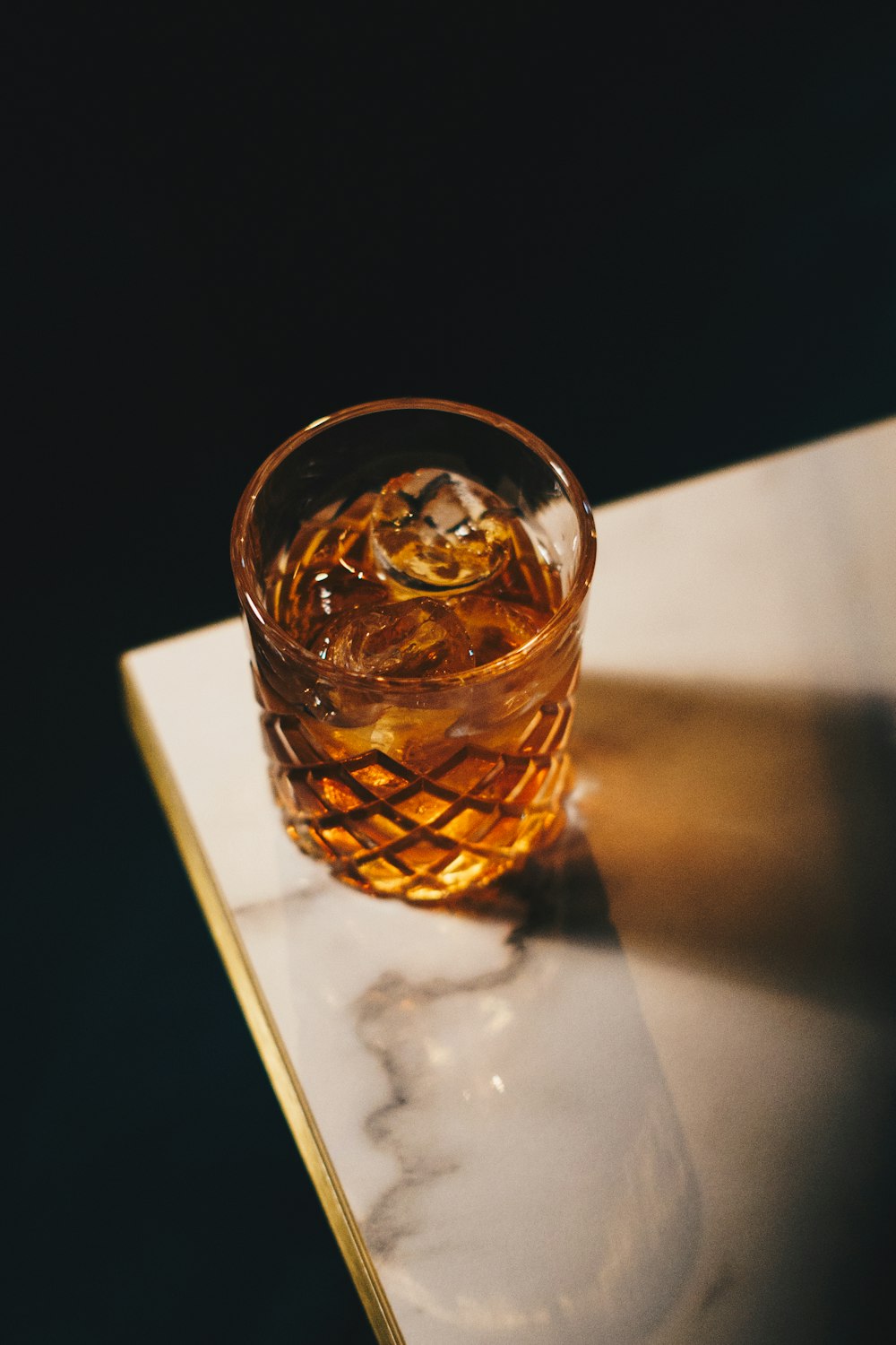 a glass of whiskey sitting on top of a table