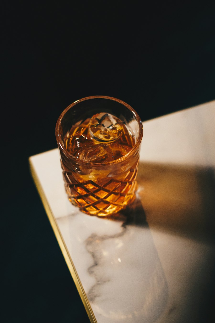 A glass of whiskey on a marble ledge
