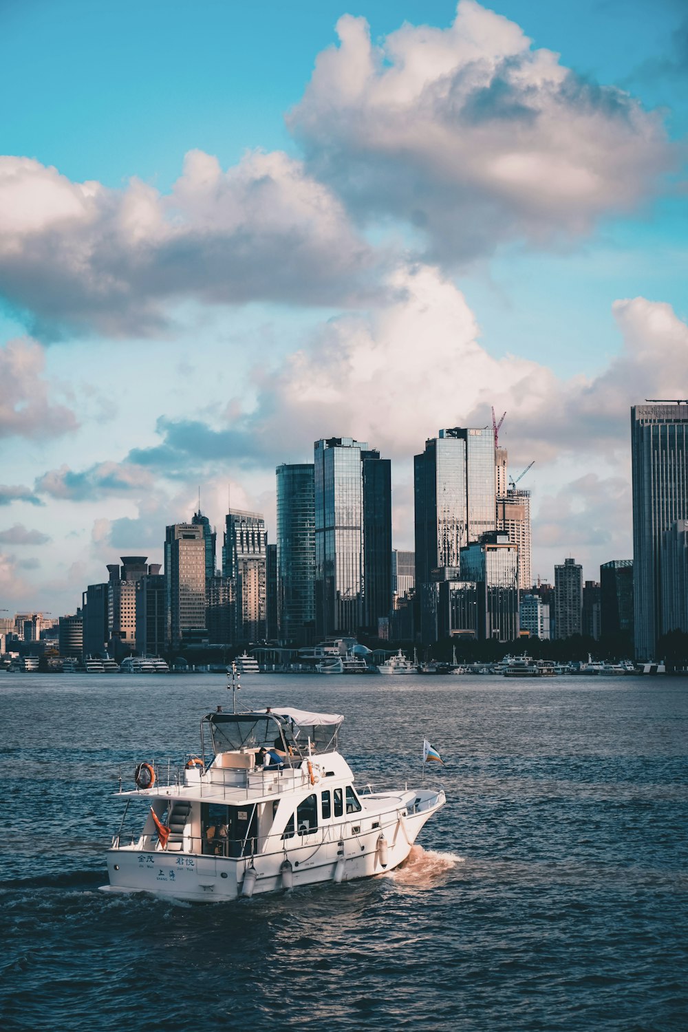 a white boat in a body of water with a city in the background