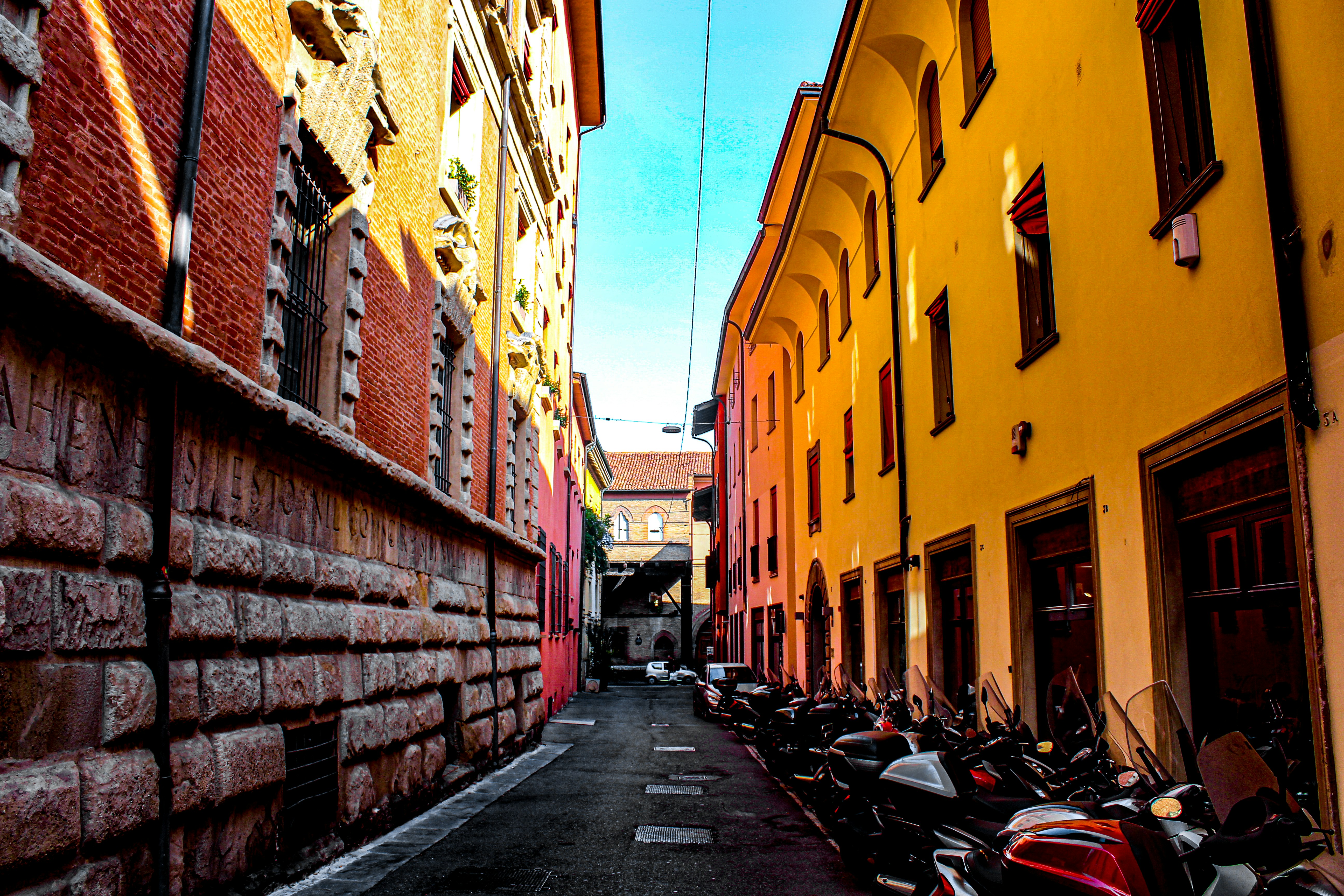 a row of motorcycles parked in front of a yellow building