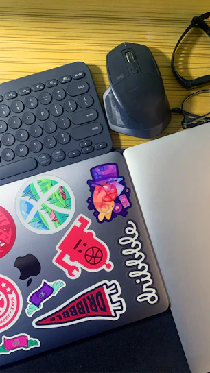 A cozy workspace with blue and white accents showcasing gadgets and colorful stickers on display.