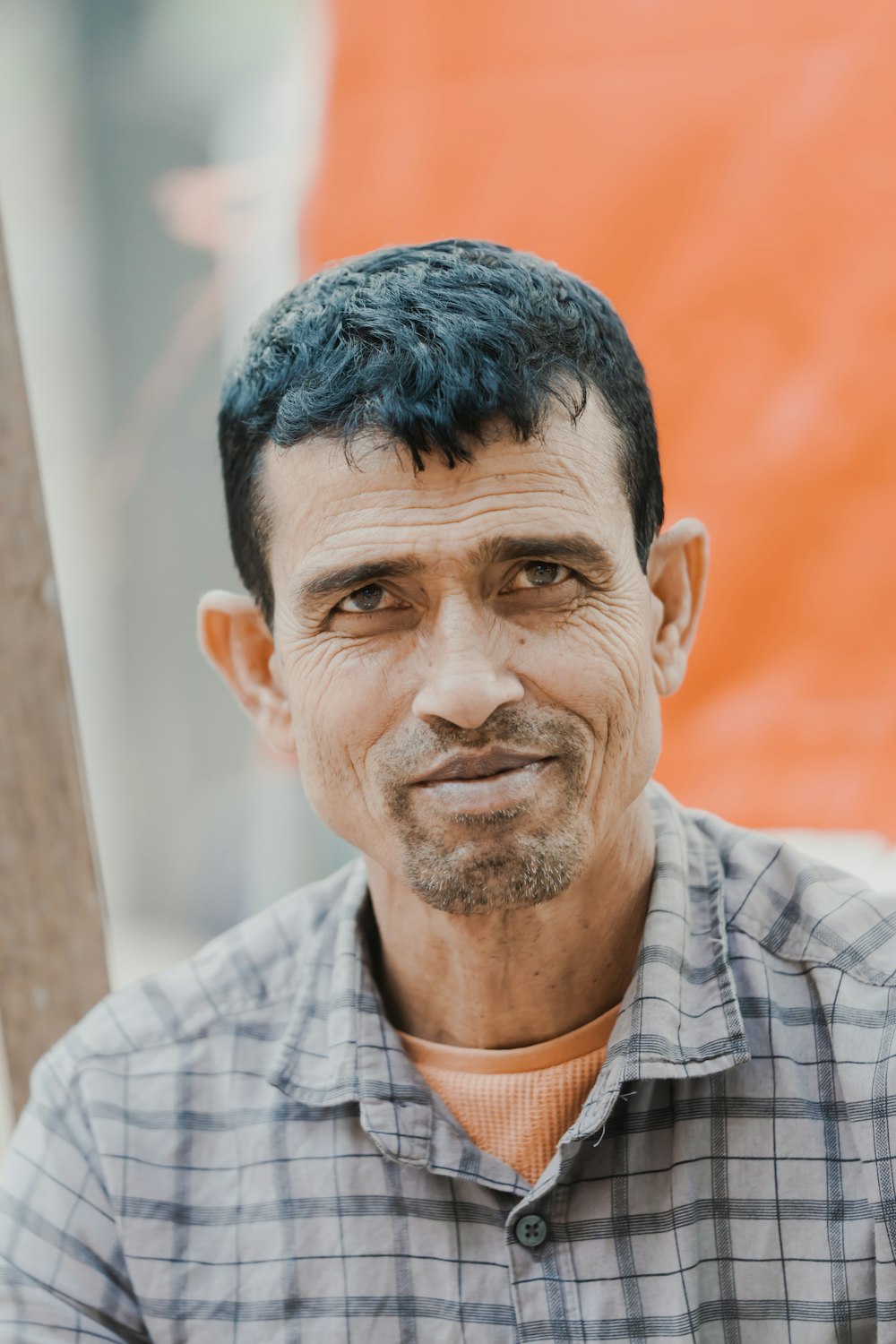 a close up of a person wearing a plaid shirt