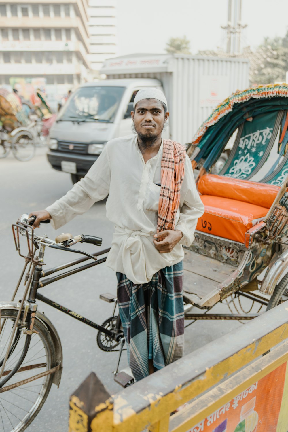 a man standing next to a bike on a street