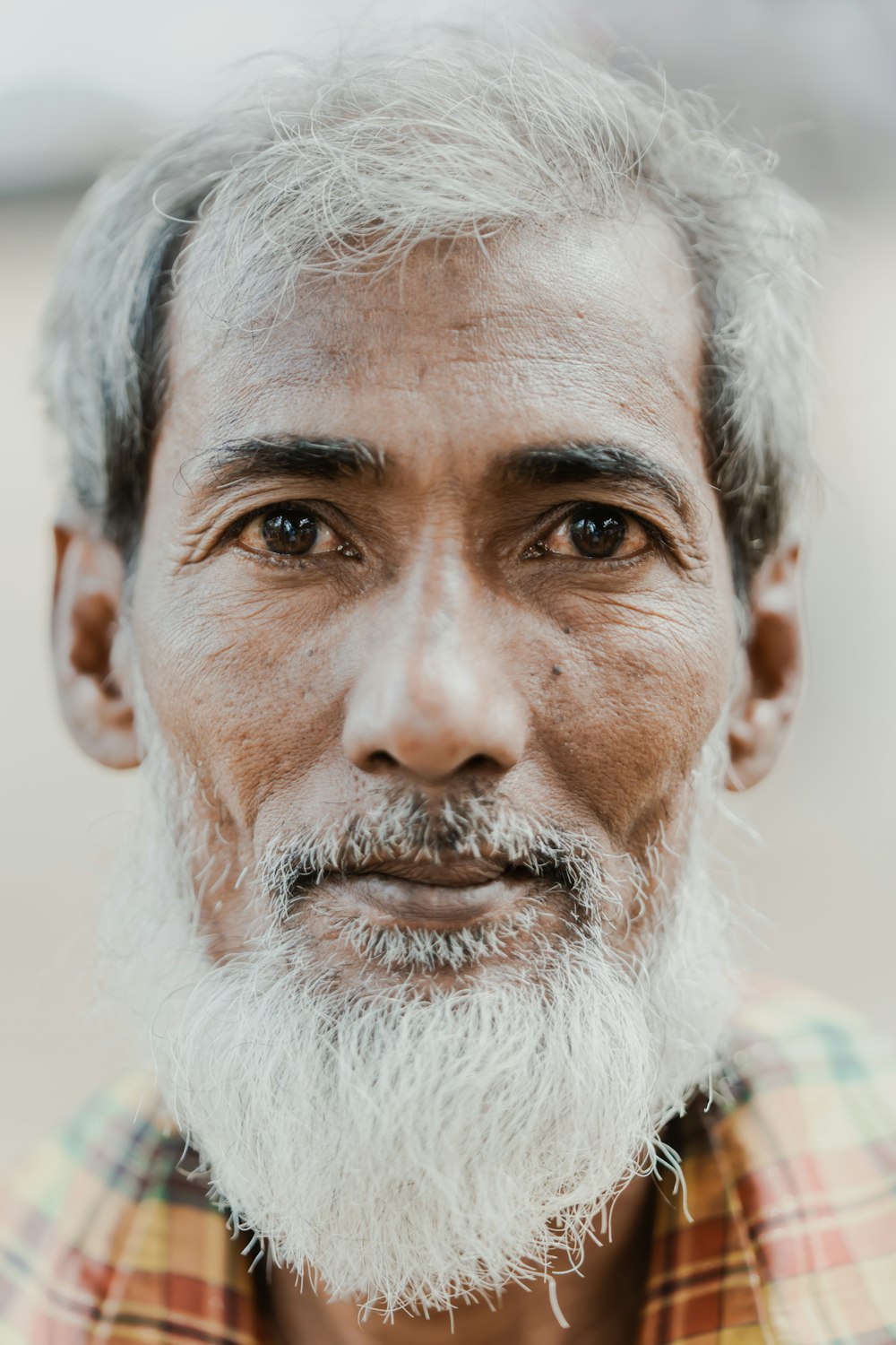 a man with a white beard and a plaid shirt