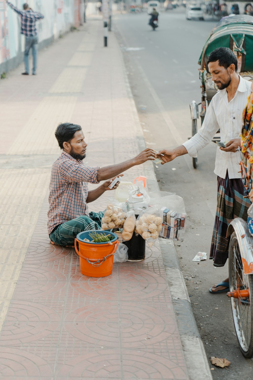 a man handing food to another man on a bike