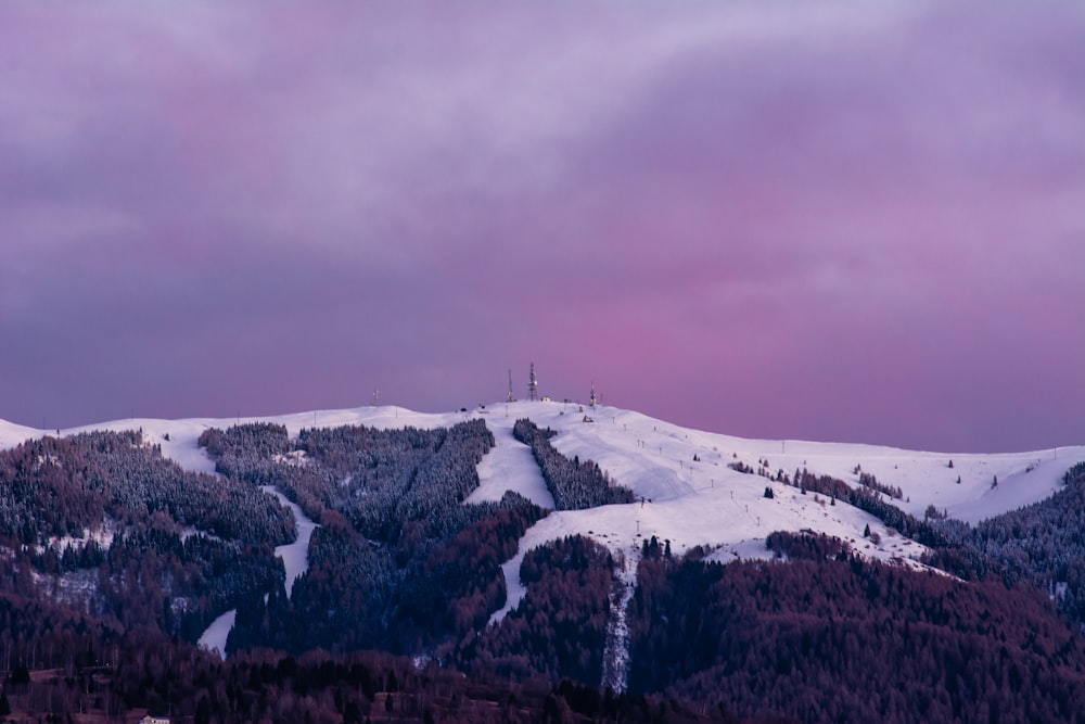 a mountain covered in snow under a cloudy sky