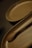 A close-up view of wooden kitchenware, including a spoon and a tray. The items are carved elegantly, showcasing smooth textures and a natural brown hue. The shallow depth of field creates a soft blur effect in the background.