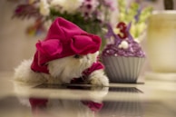 Close-up of a flancheese shaped like a sleepy cat with soft pastel pink frosting.