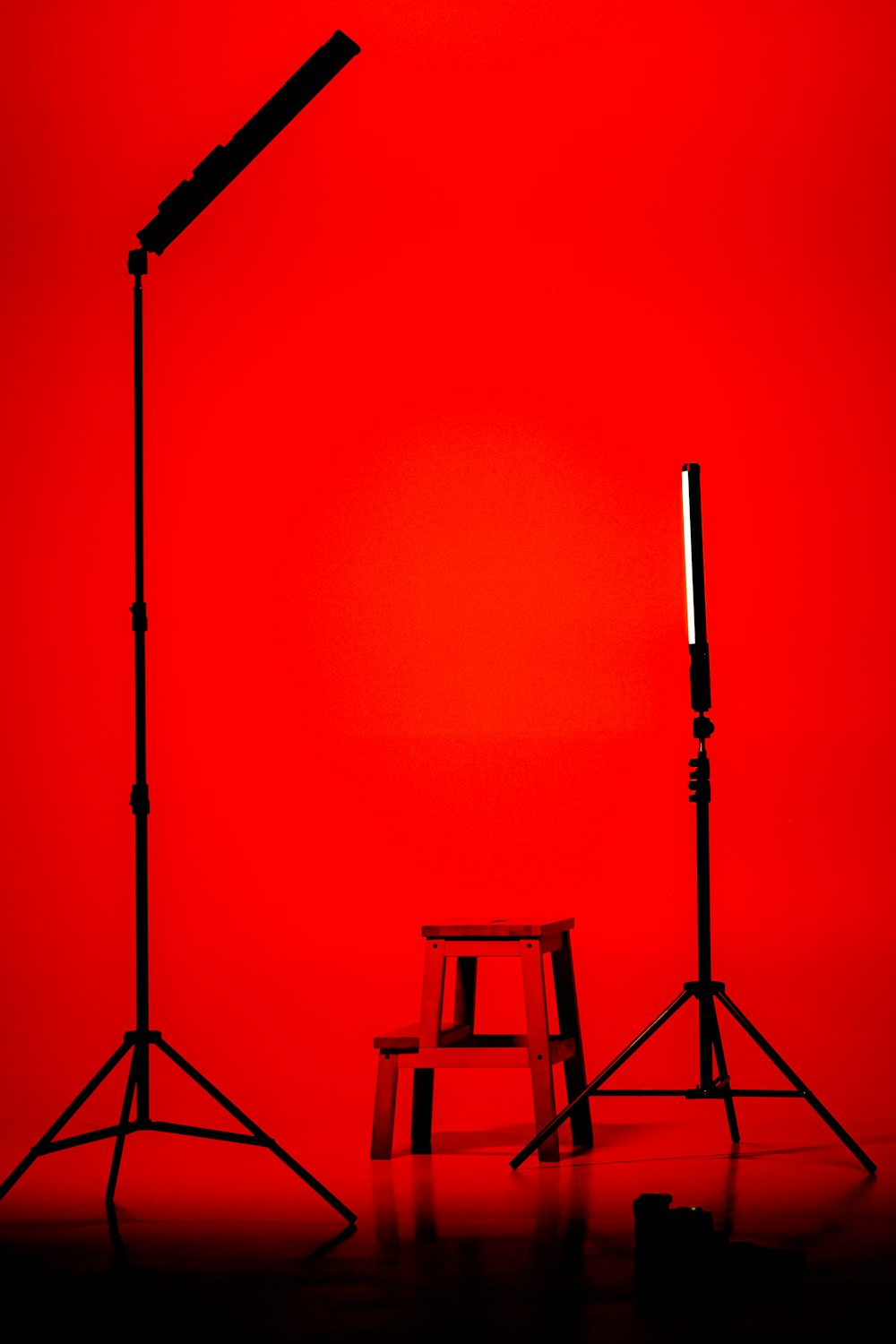 a red room with two stools and a lamp