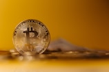 Close-up of a physical Bitcoin coin resting on a financial newspaper.