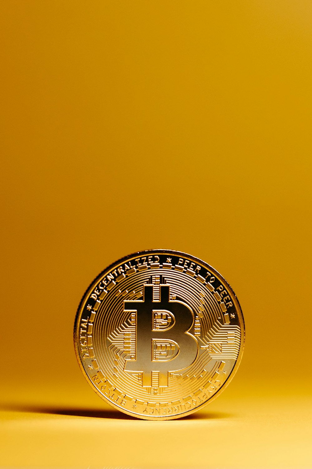 a bit coin sitting on top of a yellow surface