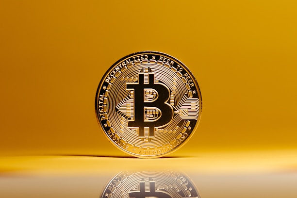 a bit coin sitting on top of a reflective surface