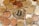 A large assortment of coins is scattered over paper currency, with a prominent Bitcoin coin at the center symbolizing cryptocurrency.