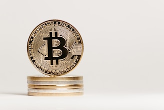 A close-up view of a stack of shiny coins with a focus on a Bitcoin, showcasing intricate engravings and the iconic Bitcoin symbol at the center.
