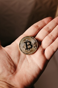 a person holding a bit coin in their hand