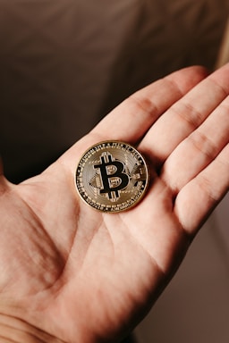 a person holding a bit coin in their hand