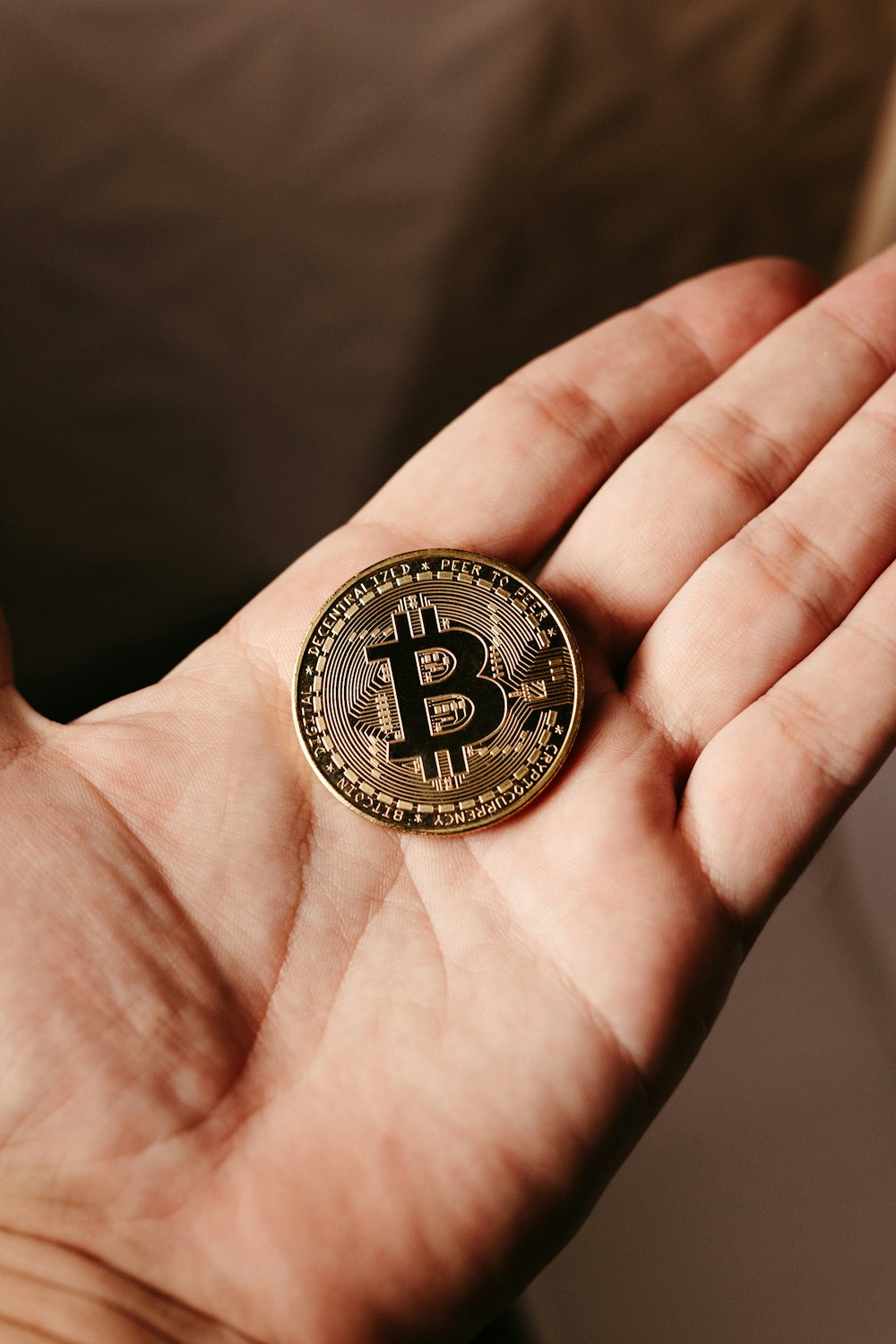 a person holding a bit coin in their hand