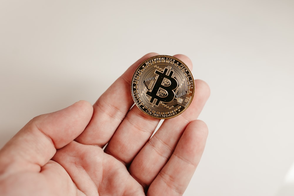 a person holding a bit coin in their hand