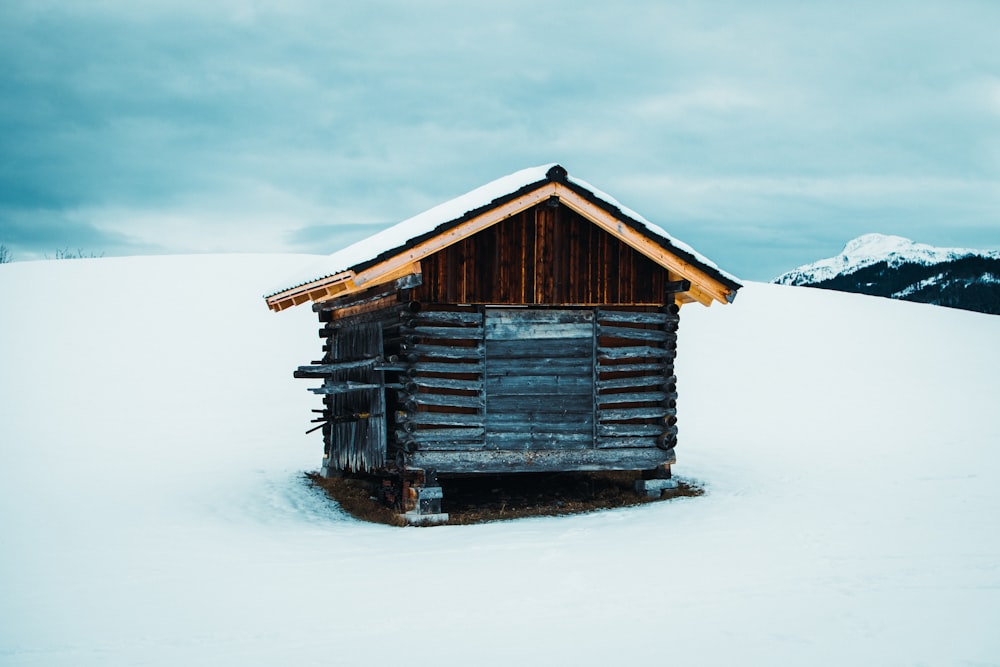 a log cabin in the middle of a snowy field