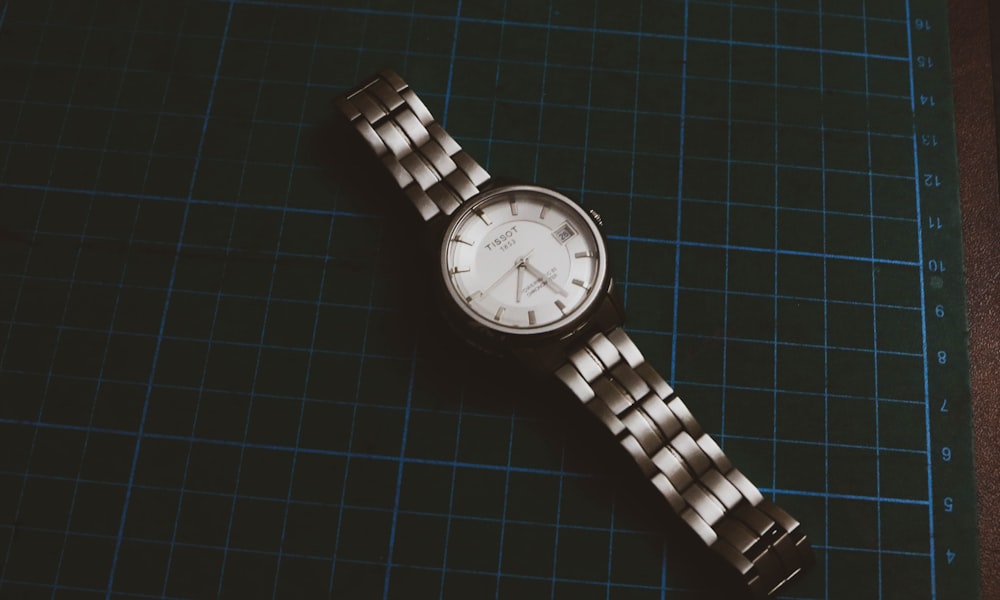 a watch sitting on top of a table next to a ruler