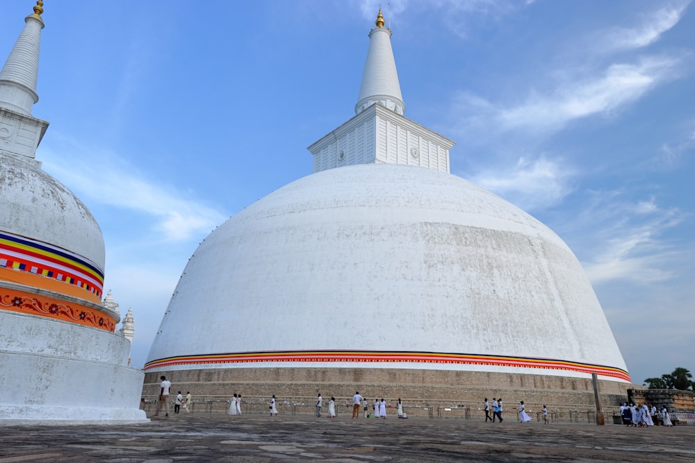 a group of people standing in front of a large white building