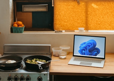 a laptop computer sitting on top of a stove top oven