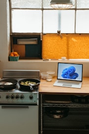 a laptop computer sitting on top of a stove top oven