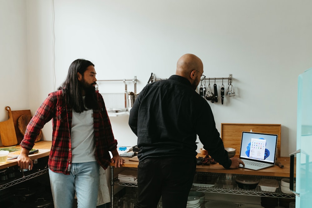 a man and a woman standing in front of a computer