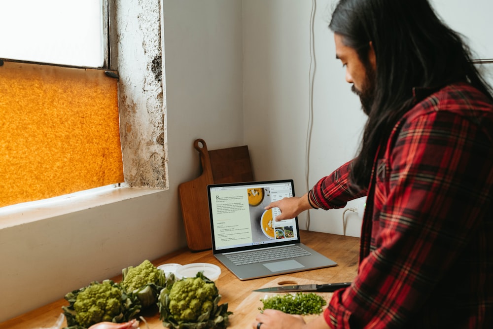 a woman standing in front of a laptop computer