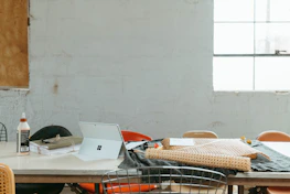 An overhead shot of a minimalist workspace with fabric swatches and design sketches spread out.