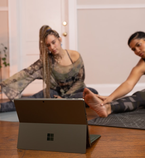 a couple of women sitting on top of a wooden floor