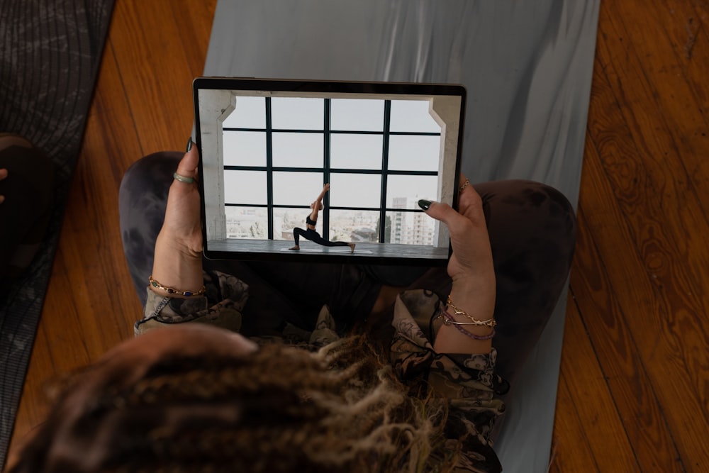 a woman holding up a tablet with a picture of a woman on it