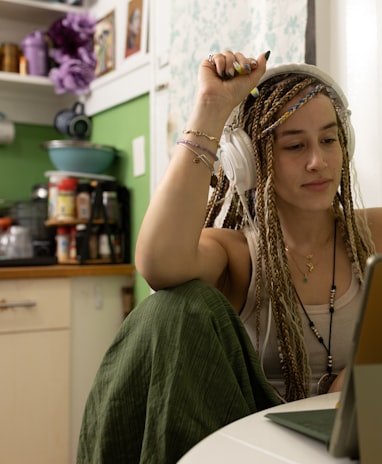 a woman with dreadlocks sitting in front of a laptop computer