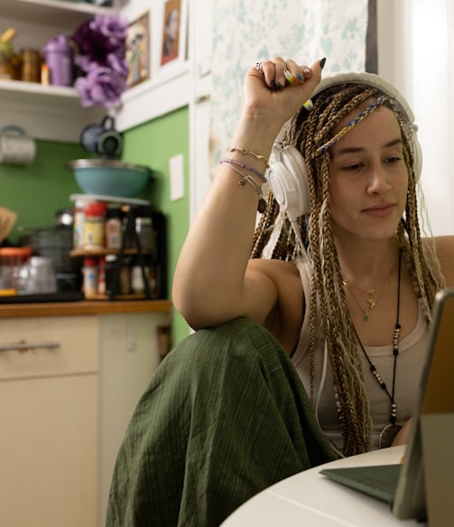 a woman with dreadlocks sitting in front of a laptop computer