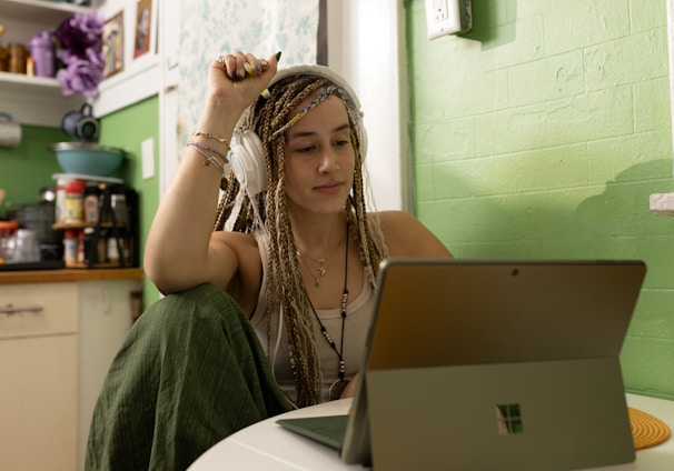 a woman with dreadlocks sitting in front of a laptop computer